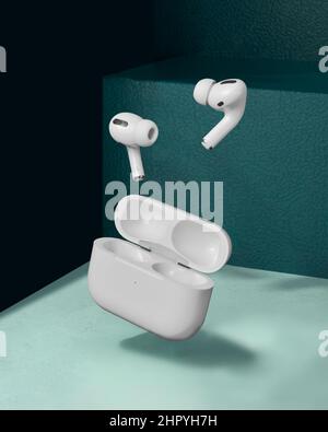 Vue des Air Pods blancs avec double microphone volant avec fond bleu Banque D'Images