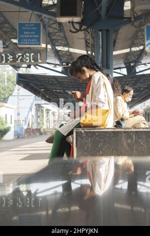 Plan vertical d'une femme attendant le train à la gare de Matunga. Mumbai, Inde Banque D'Images