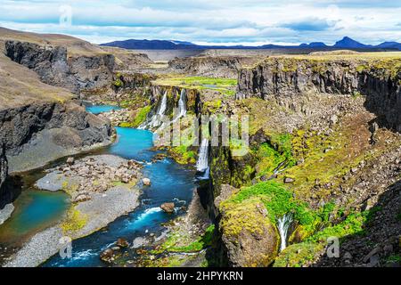 Vue sur les chutes d'eau du canyon de Sigoldugljufur et sur la rivière bleue dans les Highlands d'Islande en été. Banque D'Images