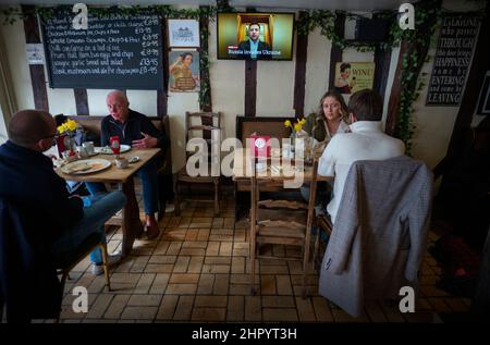 La Russie envahit l'Ukraine vue à la télévision dans le bar à vin Thaxted Essex, Royaume-Uni. 24th févr. 2022. En tant que clients de Parraches Wine Bar à Thaxted Essex UK manger leur déjeuner le poste de télévision montre le président de l'Ukraine Volodymyr Zelenskyy plaidant avec l'ouest sur la BBC après l'invasion de l'Ukraine par la Russie aujourd'hui. Crédit : BRIAN HARRIS/Alay Live News Banque D'Images