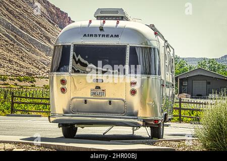 2021 06 04 Grand Junction Colorado USA - remorque Airstream pour campeurs garée sur béton avec vignes et mesa et grange derrière elle. Banque D'Images