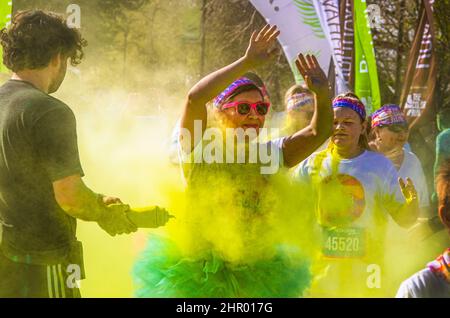 6 2019 avril Tulsa USA - Holi - Color Run à Tulsa USA - Girls in ballerina jupes levez les mains au-dessus de la tête tandis que les bénévoles aux cheveux bouclés les injecte avec y Banque D'Images