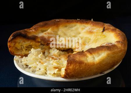 Tarte au chou maison sur une assiette blanche. Nourriture sur fond noir Banque D'Images