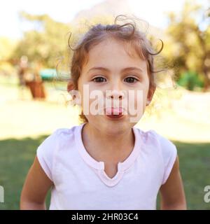 Je ne peux pas me faire. Portrait d'une petite fille tricherie qui colle à sa langue. Banque D'Images