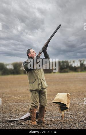 homme avec un fusil de chasse prêt et attendant que les oiseaux volent devant lui Banque D'Images