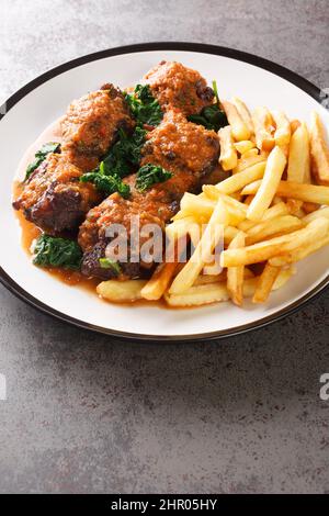 Le rabo de Toro délicieux plat en Espagne est le ragoût de queue d'aronde servi avec des frites closeup dans l'assiette sur la table. Verticale Banque D'Images