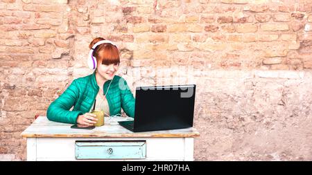 Jeune femme avec un casque utilisant un ordinateur portable au bureau de la maison - travail intelligent à distance et concept de technologie en raison de l'isolement urgence de rester à la maison i Banque D'Images