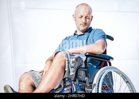 Homme handicapé avec un handicap sur fauteuil roulant en période de dépression - concept de handicap avec personne sans pouvoir assise seule sur fauteuil roulant - Socia Banque D'Images