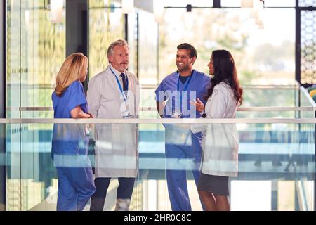 Équipe médicale multiculturelle portant des blouses et des exfoliations blanches Réunion à l'hôpital Banque D'Images