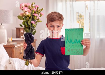 Portrait de garçon en pyjama à fleurs et carte d'anniversaire maison pour la fête des mères Banque D'Images