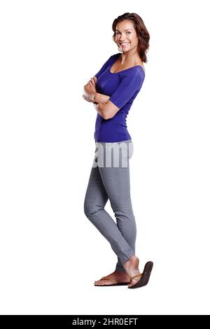 Se tenir avec style. Vue latérale sur toute la longueur d'une femme attrayante debout avec ses bras pliés et souriant largement. Banque D'Images