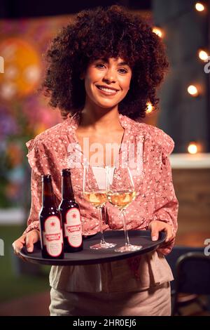 Portrait d'un serveur femme souriant tenant un plateau de boissons au Cool Bar ou au Club Banque D'Images