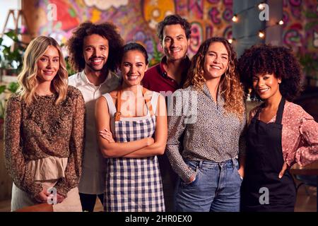 Portrait de l'équipe multi-culturelle souriante de serveurs personnel et propriétaire de bar debout dans Cool Bar ou Club Banque D'Images