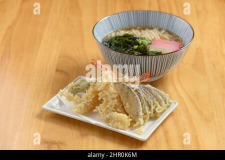 Cuisine japonaise Tempura Udon nouilles avec légumes dans un plat et un bol isolés sur fond de bois vue du dessus Banque D'Images