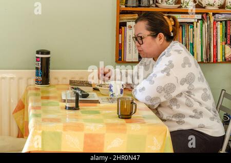 Une femme asiatique s'est assise à une table pour le petit déjeuner. Banque D'Images