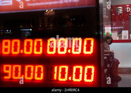 Moscou, Russie. 24th de février 2022 client de la Fora Bank passé un tableau numérique affichant les taux actuels à l'extérieur d'un bureau de change. En 10am, la Bourse de Moscou a rapporté que le dollar américain et l'euro se négociaient respectivement à 89,6 et 100 contre le rouble russe, atteignant ainsi leurs sommets historiques Banque D'Images