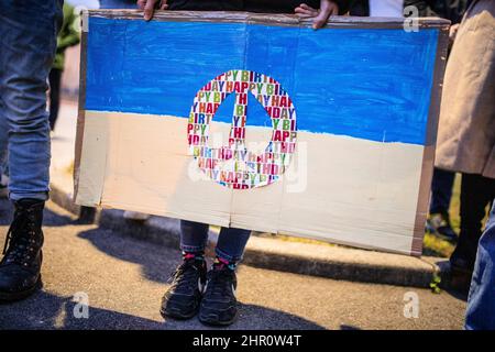 Stuttgart, Allemagne. 24th févr. 2022. Une jeune femme tient un panneau avec le drapeau ukrainien et un symbole de paix dans ses mains lors d'une manifestation devant le Consulat général de Russie. Credit: Christoph Schmidt/dpa/Alay Live News Banque D'Images