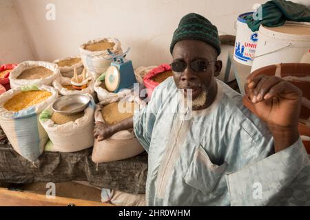 Un vendeur vend des céréales et des légumineuses à sa stalle de Kolda, au Sénégal, en Afrique de l'Ouest. Banque D'Images