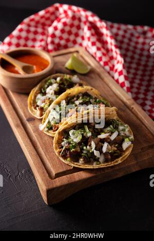 Tacos de Suadero. Viande frite dans une tortilla au maïs. Cuisine de rue de CDMX, au Mexique, traditionnellement accompagnée de coriandre, d'oignon et de sauce rouge épicée Banque D'Images