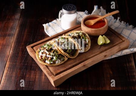 Tacos de Suadero. Viande frite dans une tortilla au maïs. Cuisine de rue de CDMX, au Mexique, traditionnellement accompagnée de coriandre, d'oignon et de sauce rouge épicée Banque D'Images