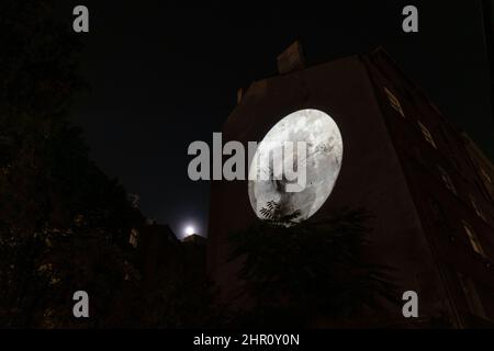 3d cartographie de la lune sur le mur d'un bâtiment sous une pleine lune la nuit. Banque D'Images