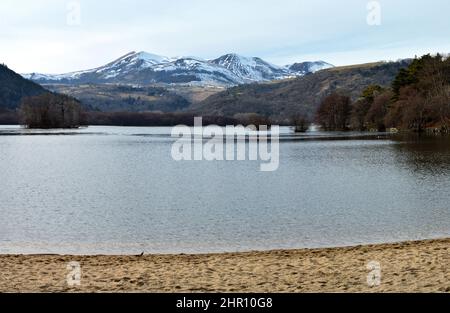 Une plage au-dessus d'un lac de montagne en face d'une montagne volcanique en Auvergne Banque D'Images