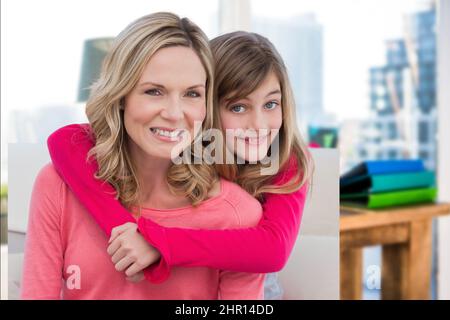 Image composite de la mère et de la fille caucasiennes souriant contre le bureau en arrière-plan Banque D'Images