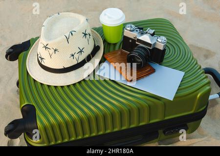 Repos et déplacement. Une valise ou un sac à bagages avec un chapeau de soleil sur le fond de la plage, billets d'avion, lunettes de soleil, passeport, vacances, copier l'espace. Banque D'Images