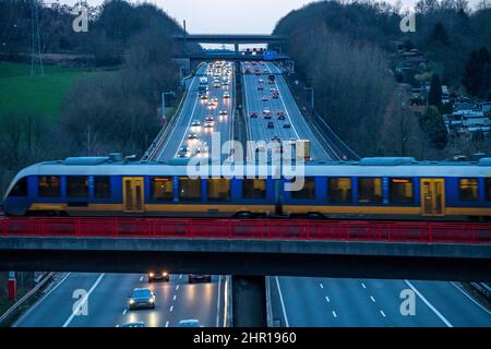 L'autoroute A3, circulation en soirée sur 6 voies, train local S-Bahn, Regiobahn, S28, en traversant l'autoroute, Sur le chemin entre Kaarst et Wupper Banque D'Images