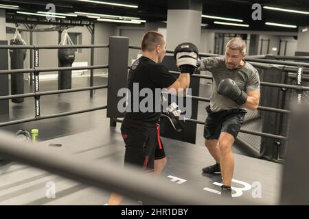 RUSSIE, MOSCOU - 14 FÉVR. 2022: Boxe entraînement gym femme sac, pour la force kickboxing de l'athlète pour le corps fort, muscle personne. Vêtements de sport Banque D'Images