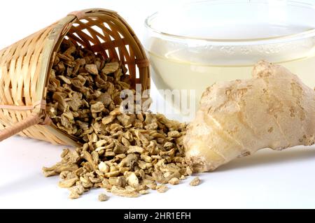 Gingembre, gingembre commun, gingembre de cuisine, gingembre de canton (Zingiber officinale), racines de gingembre en morceaux et une tasse de thé, coupé Banque D'Images