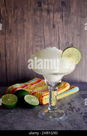 margarita salée congelée avec tranche de lime dans un verre clair et un fond rustique Banque D'Images