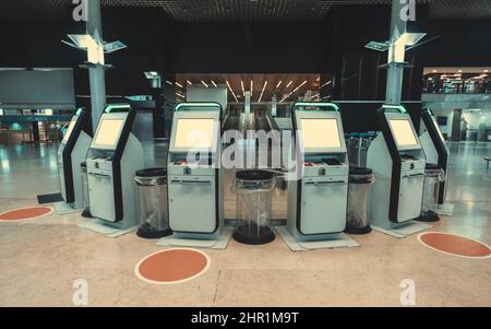 Une rangée arrondie de machines électroniques d'enregistrement de vol libre-service dans un aéroport moderne avec une maquette de leurs écrans LCD; six terminaux de billets électroniques Banque D'Images