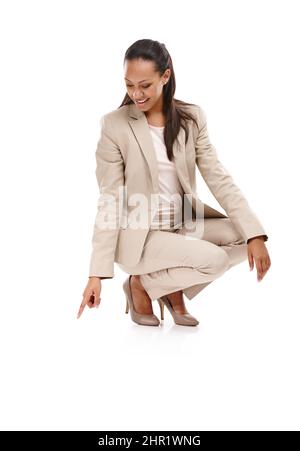 Nulle part où aller, mais vers le haut. Prise de vue en longueur d'une jeune femme attirante dans un costume qui s'enroule vers le bas et pointant vers le sol isolé sur blanc. Banque D'Images