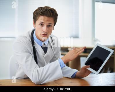Nous avons un traitement pour cela. Photo d'un jeune médecin expliquant quelque chose en tenant une tablette numérique. Banque D'Images