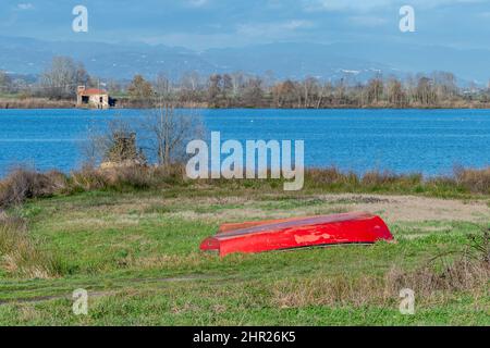 Un bateau en bois rouge est capsized près de la rive du lac Gherardesca, Lucca, Italie Banque D'Images