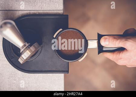 Le barista falsification du café dans le porte-filtre à l'aide d'un sabotage. Gros plan sur le processus de préparation du café frais Banque D'Images