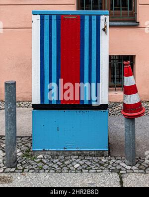 Rouge blanc et bleu. Utilty Box colorée et cône de circulation sur la chaussée pavée à Mitte, Berlin Banque D'Images