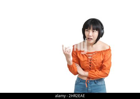 Jeune femme asiatique avec un casque pointant vers quelque chose de surpris, isolé. Banque D'Images