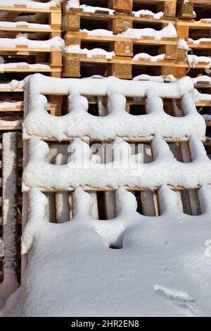 palettes industrielles en bois enneigé en hiver Banque D'Images