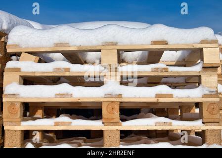 palettes industrielles en bois enneigé en hiver Banque D'Images