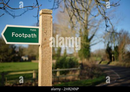 Panneau de chemin de pied pointant à droite sur un poteau en bois par une route à Suffolk, Royaume-Uni. Banque D'Images