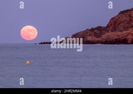 lune rose s'élevant sur la mer méditerranée depuis la plage de pals sur la costa brava Banque D'Images