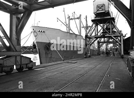 PLAN 205 le 1964 Tamise construit MAÎTRE NICOS, un d'une série de navires semblables construits à divers chantiers pour PhOcean Ship Agency Limited amarré avec des dockers déchargeant sur le quai de Newcastle 1969 Banque D'Images