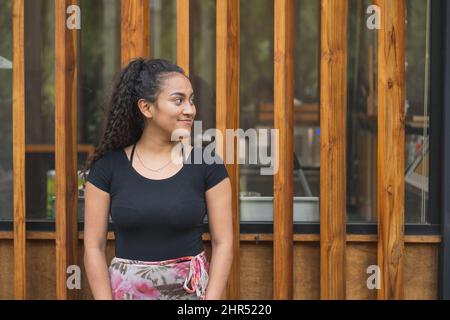 Jeune femme hispanique souriant à l'extérieur Banque D'Images