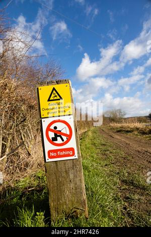 Lignes aériennes d'électricité avertissant les pêcheurs sur le chemin de halage du canal de Grantham, Woolsthorpe par Belvoir, Lincolnshire. Danger, pas de pêche Banque D'Images