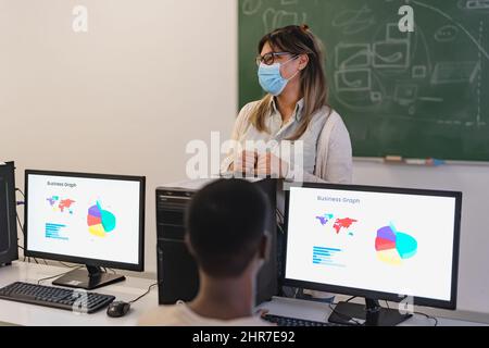 Professeur hispanique enseignant au lycée tout en portant un masque facial pendant la pandémie de virus corona - concept d'éducation Banque D'Images
