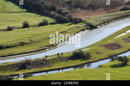 Brighton UK 25th février 2022 - Walkers près de la rivière Cuckmere et de la vallée près d'Alfriston , Sussex lors d'une belle journée ensoleillée avec des prévisions météorologiques plus stables pour les prochains jours : Credit Simon Dack / Alay Live News Banque D'Images