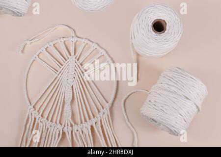 Cordon en coton macrame et objet mural fini sur fond beige Banque D'Images