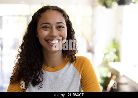 Portrait d'une jeune femme afro-américaine souriante aux cheveux bouclés au café Banque D'Images